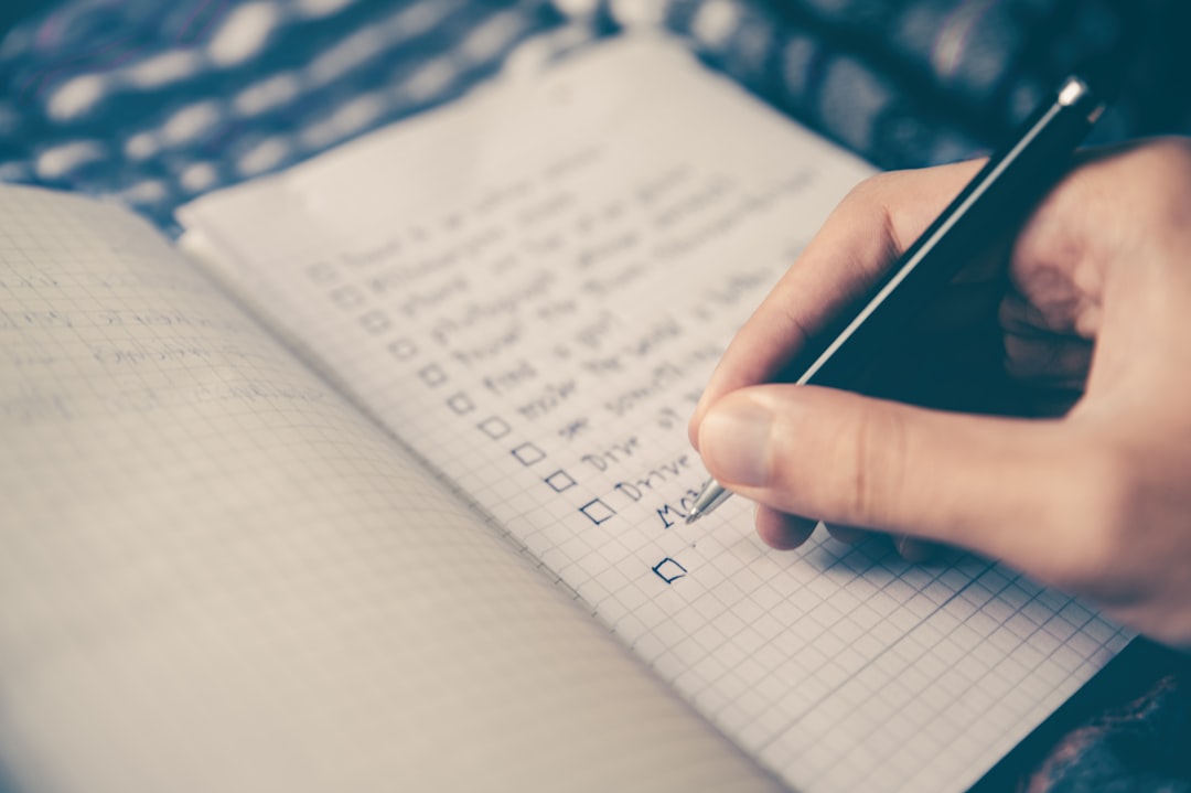 Personne préparant sa valise avec une checklist à côté